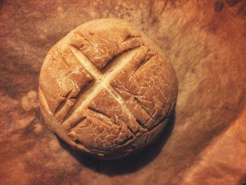 Image of homemade bread with an x cut into the crust
