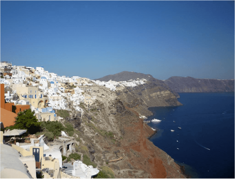 Greek coastline with houses on a cliff over the water